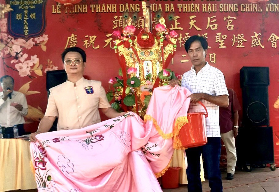 邹国荣理事长（左）移交《观音莲花宝灯》，由凌钦廷先生代表接领。