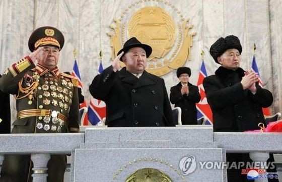 朝鲜国务委员会委员长金正恩（中）登上阅兵检阅台。（图：韩联社/朝中社）