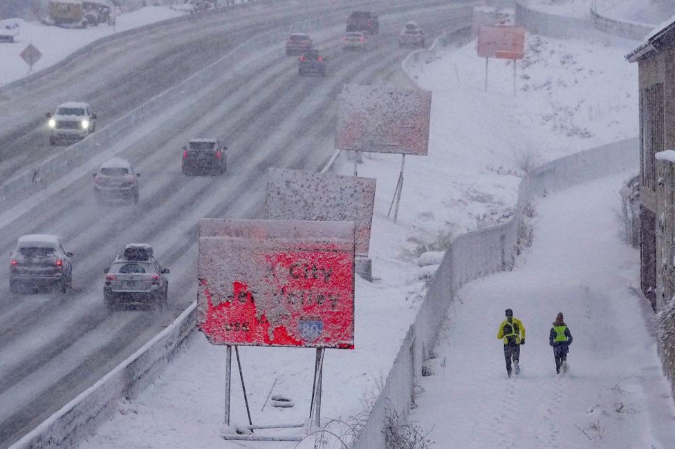 22日，人们在美国盐湖城积雪的道路上出行。（图：新华社）