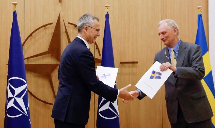 图为2022年5月18日，北约秘书长斯托尔滕贝格（左）在比利时布鲁塞尔接受瑞典驻北约大使递交的瑞典加入北约的申请。（图：新华社）