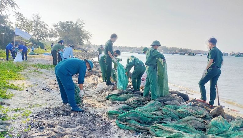 青年突击队员们正在收集海滩上的塑料垃圾。（图：人民军队报）