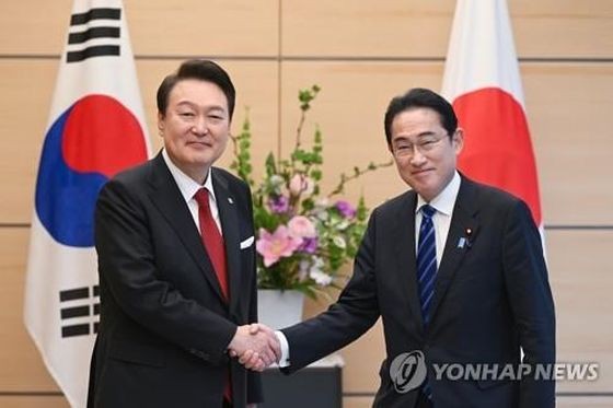 3月16日下午，在位于东京的日本首相官邸，韩国总统尹锡悦（左）同日本首相岸田文雄在举行小范围会谈前握手合影。（图：韩联社）