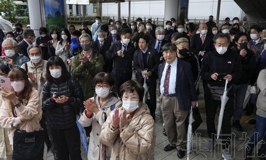 日本第20届统一地方选举的政令市长选举发布公告，人们在聆听街头演讲。3月26日上午摄于JR大阪站。（图：共同社）