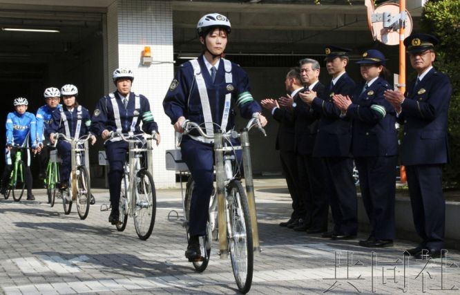 3月22日，警察戴着头盔、骑着自行车从东京警视厅月岛警署出发。（图：共同社）