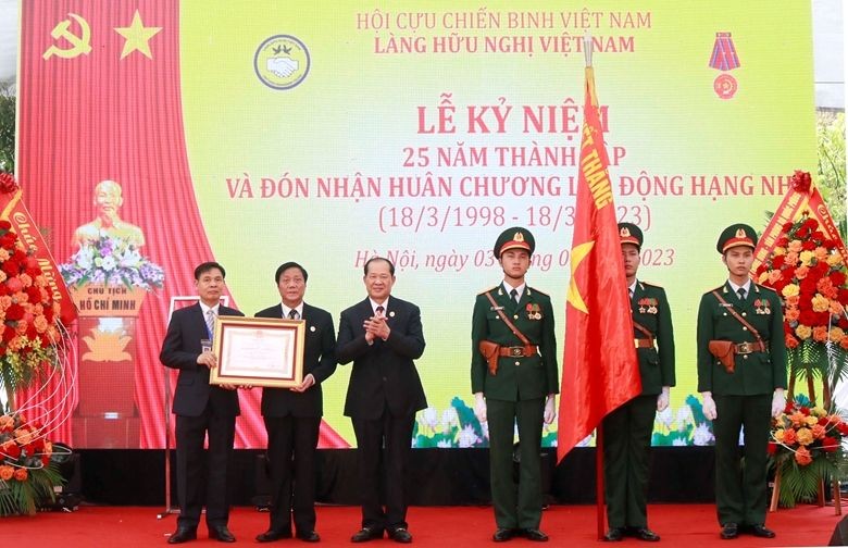 越南退伍军人协会中央主席闭春长（左三）上将代表党和国家领导向越南友谊村授予二等劳动勋章。（图：范强）