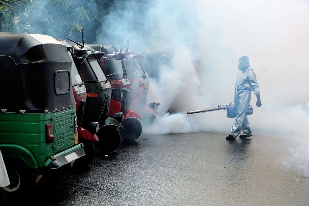 2021年6月6日，工作人员在斯里兰卡首都科伦坡一个居民区喷洒药品消灭蚊虫。（图：新华社）