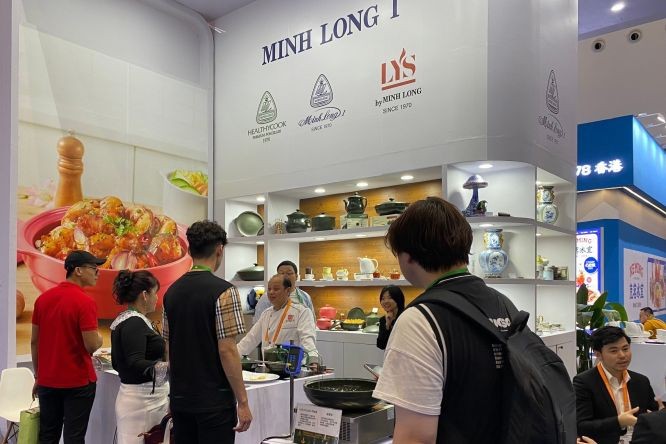 中国消费者在明隆一展位品尝养生瓷锅烹煮的菜肴。