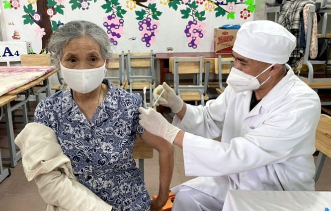 医护人员在给一位老大娘施打新冠疫苗加强针。（图：安然）