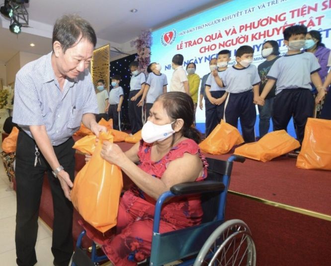 第十一郡茶山庆云南院住持周华邦代表赞助单位向残疾人士赠送礼物。