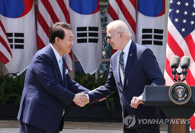 当地时间4月26日，在美国白宫，韩国总统尹锡悦（左）和美国总统拜登在联合记者会上握手。 （图：韩联社）