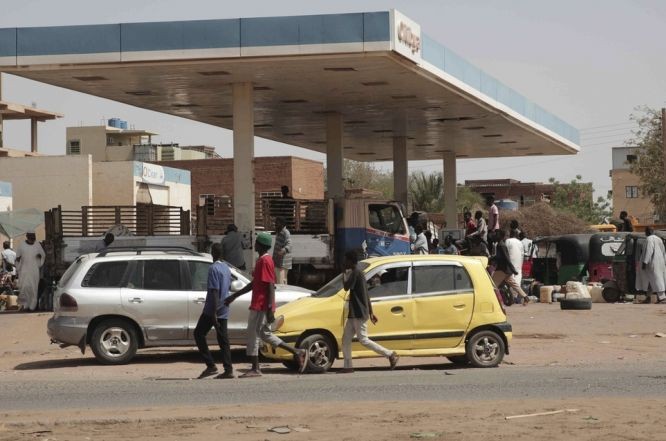 苏丹冲突持续，民众在一个油站等候领取物资。（图：AP）