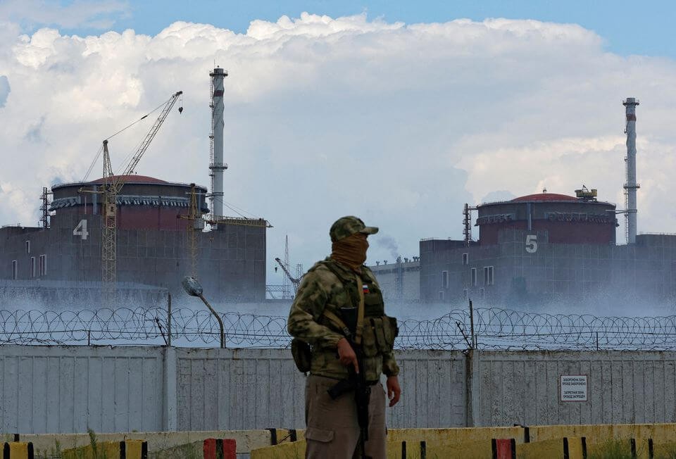 图为一名制服上有俄罗斯国旗的军人在扎波罗热核电站附近站岗。 （图：路透社）