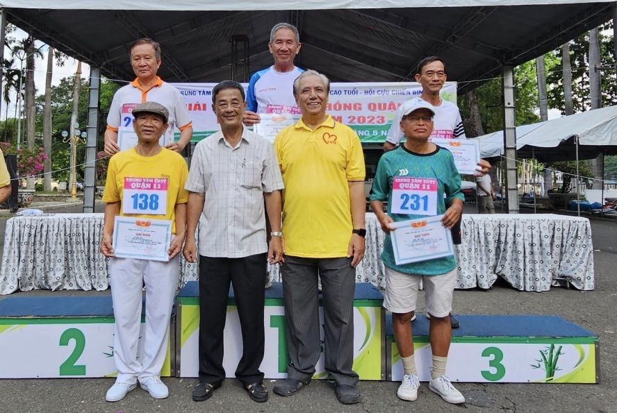 第十一郡越南祖国阵线委员会常务副主席林园德（前排左二）和郡高龄人会主任朱杞文（前排右二）向获奖者颁奖。