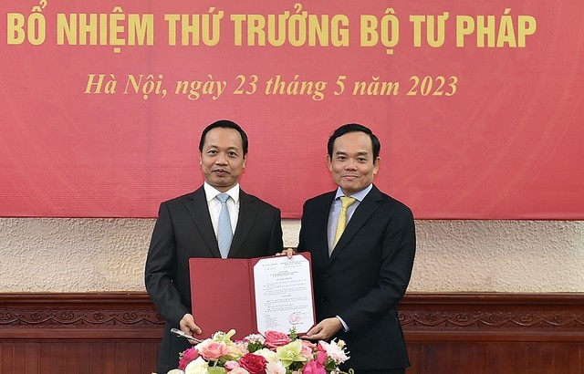 陈俊勇同志（左）从政府副总理陈留光手中接过并展示人事委任《决定》。（图：VGP）