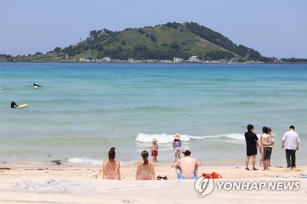 5月23日，在济州市翰林邑的挟才海水浴场，游客畅享夏日海滨的气息。（图：韩联社）