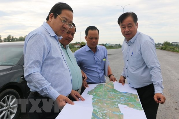 隆安省人委会副主席阮明霖（左）亲往视察实地并查看途径该省的环市3路地图。（图：越通社）