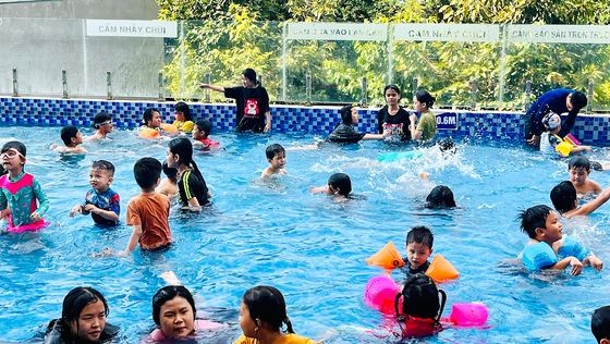 孩子们在第十二郡协成居民区的游泳池学习游泳。