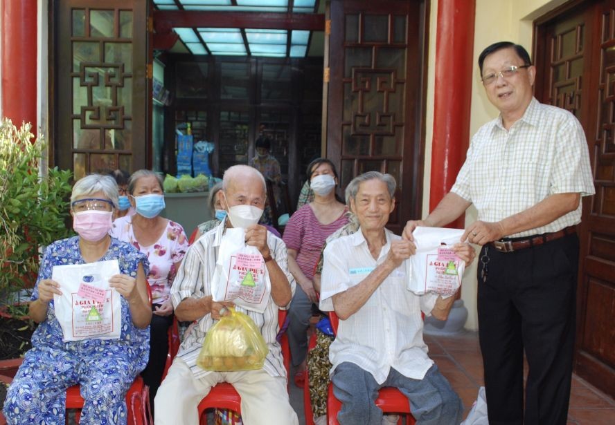 二府会馆副理事长谢忠成（右一）向高龄乡亲赠送粽子。