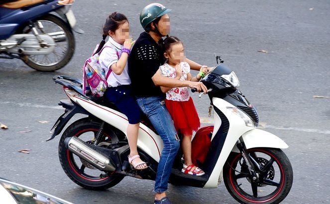 让孩子在摩托车前坐立，也不戴安全帽的情况很普遍，真的太危险了。