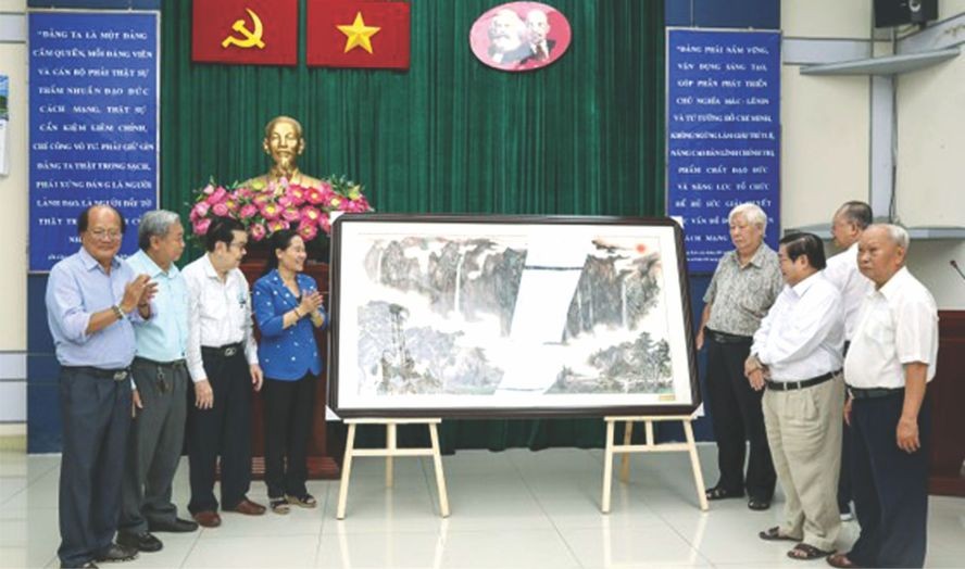 市委副书记、市人民议会主席阮氏丽接收第五郡华人会馆赠送的水墨画纪念品。