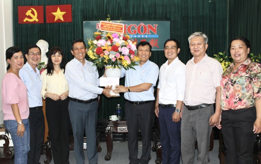 市委民运处副主任陈春田（左三）向本报主编阮玉英赠送鲜花。