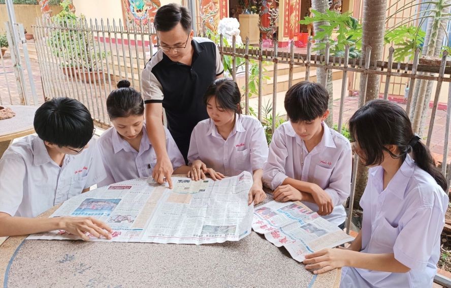 同奈省隆庆市光正学校师生阅读华文《西贡解放日报》。