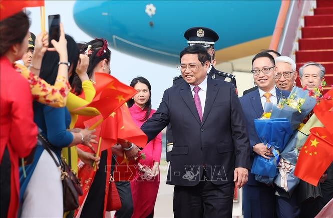 越南驻中国大使馆干部、职员代表和在中国越南人社群代表迎接政府总理范明政。（图：越通社）