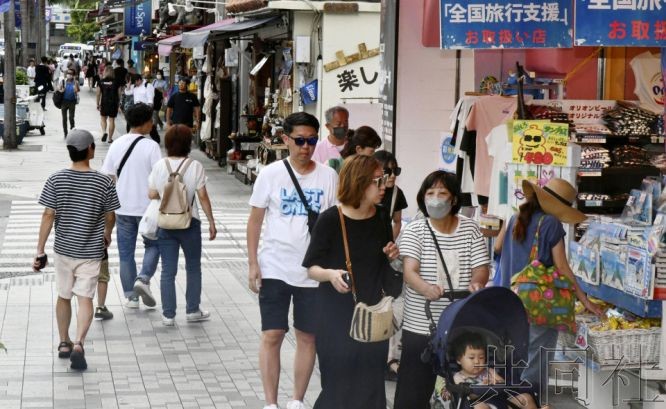 图为6月30日，冲绳县那霸市中心的大街上，人们往来交错。（图：共同社）