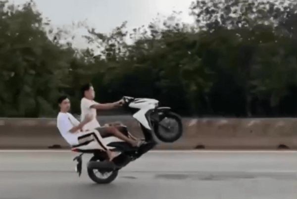 杨许黄云骑着摩托车载着阮文家杰翘头单轮行驶。（图：视频截图）