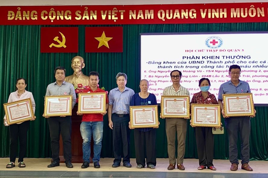 第五郡人委会副主席阮武春奇向积极捐血者颁发市人委会奖状。