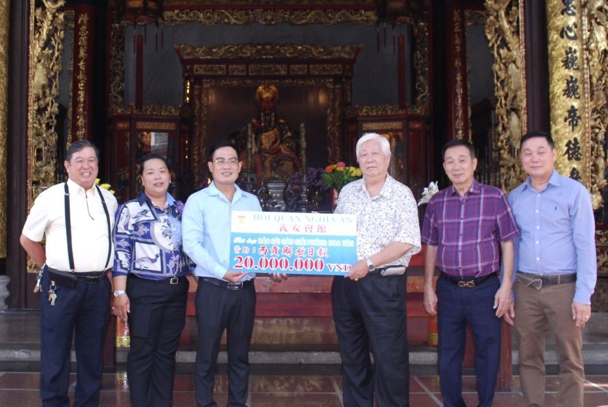 义安会馆理事长陈裕（右三）、副理事长郑学才和副理事长谢平国把赠款交给本报领导。