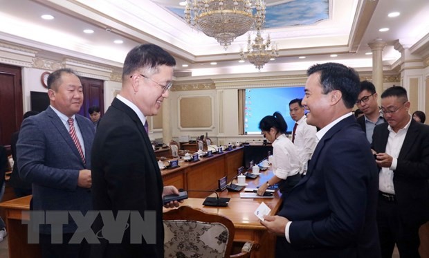 市人委会副主席裴春强(前右)与越南三星工程建设公司执行副总经理韩相德(音)交谈。（图：越通社）