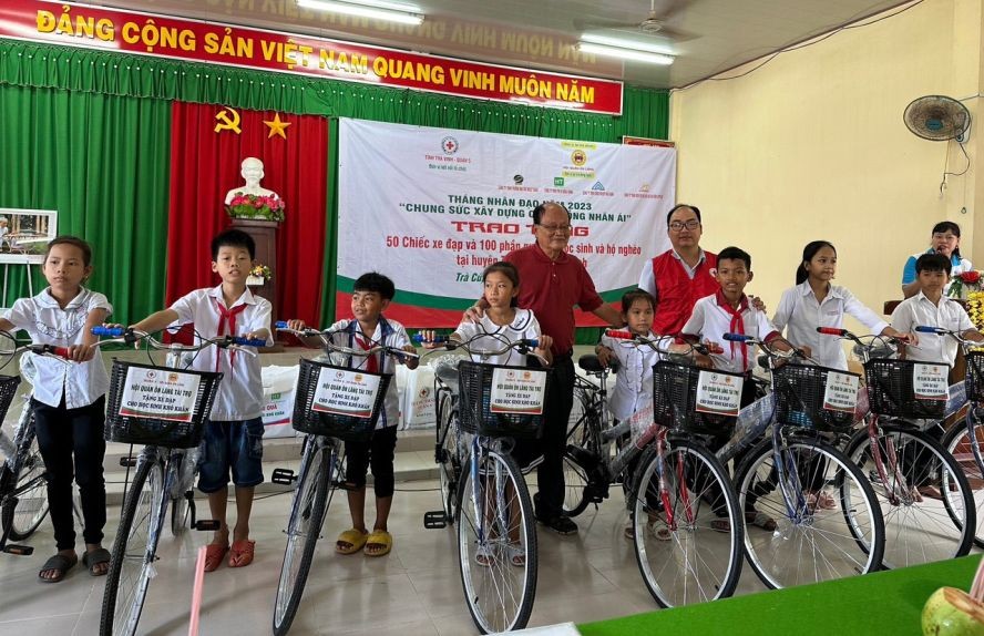 温陵会馆理事长洪世真(后排左一)与红十字会代表赠送自行车给学生。