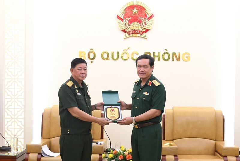 国防部副部长武海产上将（右）向老挝人民革命党中央委员、国防部副部长翁坎中将赠送纪念品。（图：人民军队报）