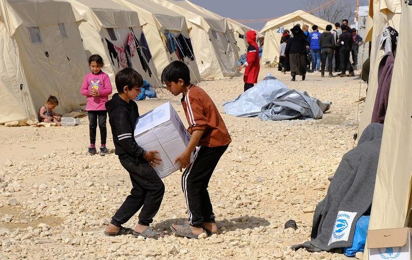 在叙利亚境内流离失所者营地，儿童正在搬运救援物资。（图：联合国）