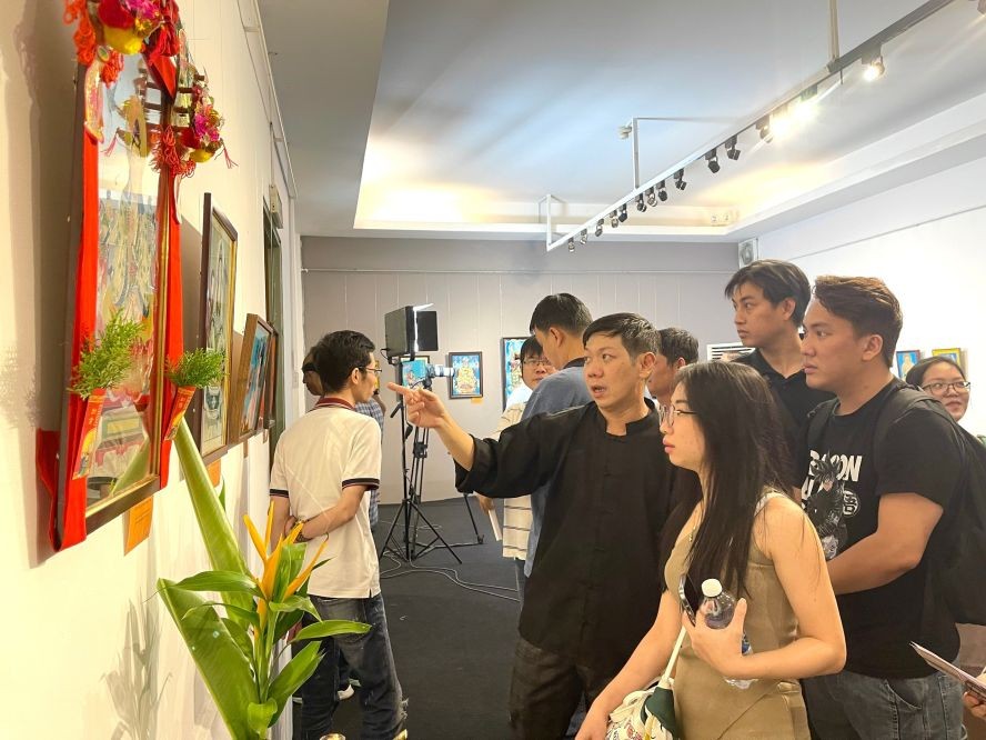 华青收藏家刘金钟向年轻观众介绍华人镜画。