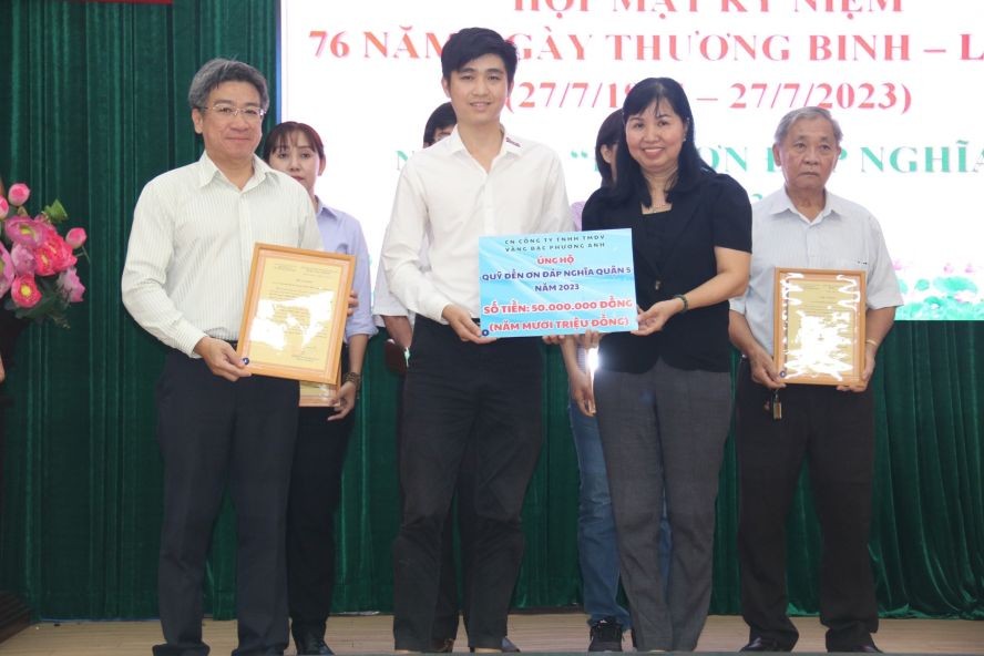 第五郡人委会副主席阮武春奇(左一)接受芳英金铺赞助5000万元。