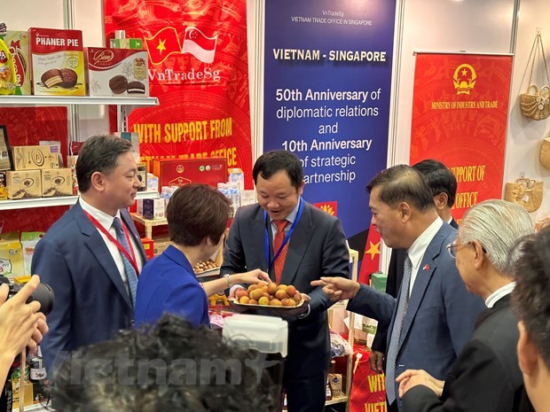 梅福勇大使与高春胜商务参赞请参观者品尝越南的新鲜荔枝。