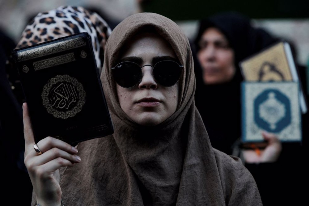图为抗议者手持《古兰经》在瑞典驻土耳其伊斯坦堡总领事馆外示威。（图：路透社）