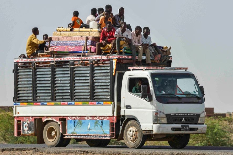 当地时间2023年6月22日，苏丹喀土穆东南约80公里的卡姆林地区，人们在一辆卡车上沿着从喀土穆到瓦德马达尼的道路行驶。（图：AFP）