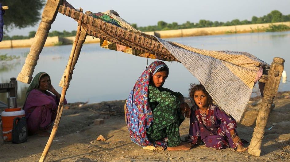 在巴基斯坦信德省，一家人在逃离遭受洪水袭击的家园后，在路边栖身。（图：联合国）