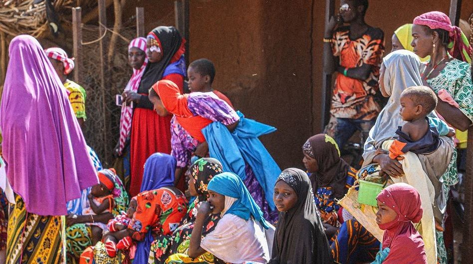 妇儿在尼日尔塔瓦地区的粮食计划署分发处等待领取口粮。（图：联合国）