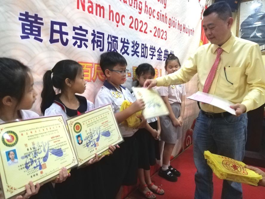 黄氏宗祠理事长黄锦雄向小学生们颁奖。