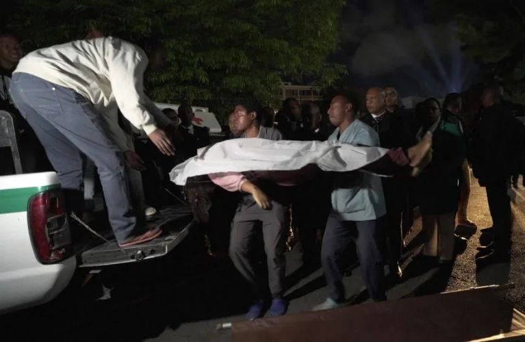 救援人员正在将死者遗体送往医院。（图：AFP）