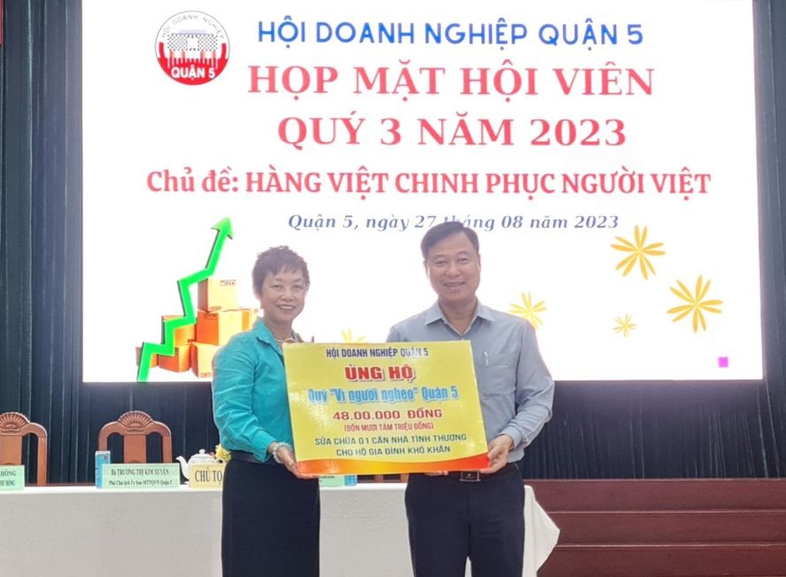 第五郡商会主席苏慧兰（左）将善款交给郡越南祖国阵线委员会领导。