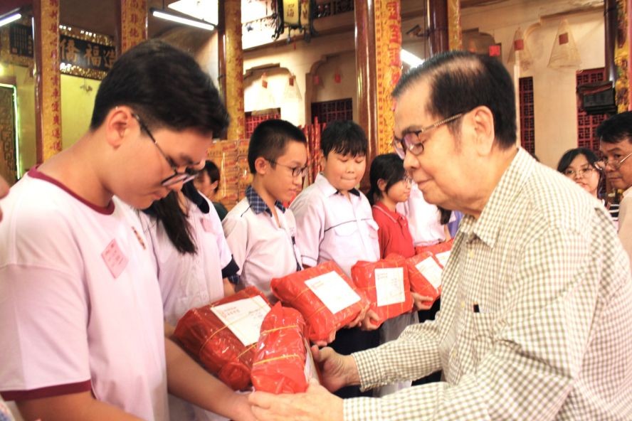 海南会馆理事长吴清华向华人子弟派奖助学金。