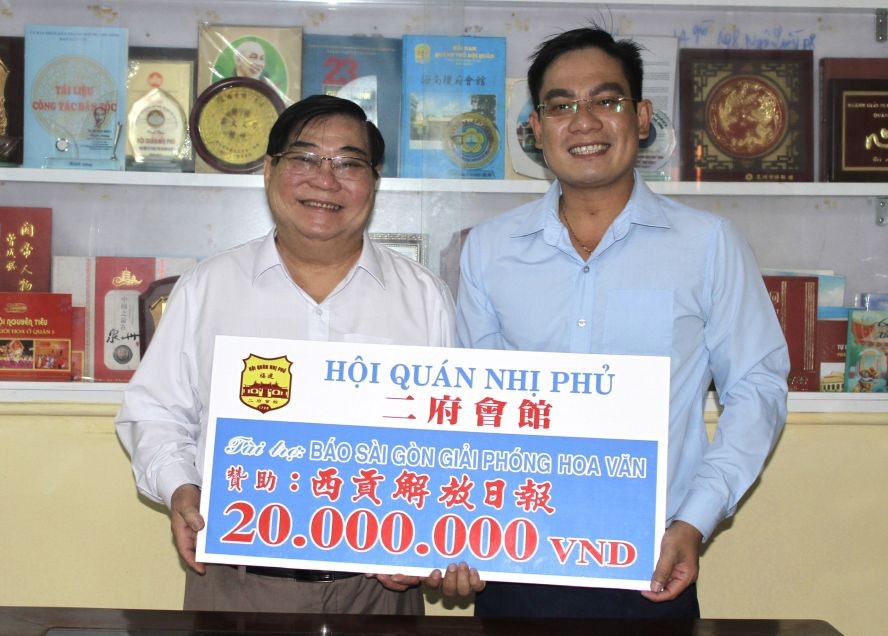 二府会馆理事长彭伟强将2000万元购买春刊经费交给本报编委文忠孝。