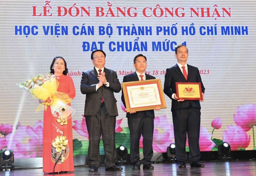中央理论委员会主席阮春胜（左二）向市干部学院颁授达一级标准证书。（图：越勇）