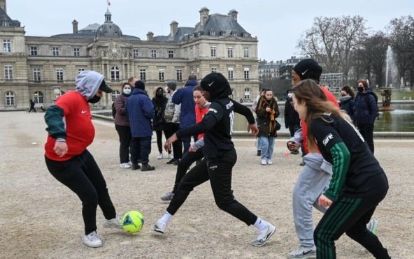 法国去年禁止女球员戴头巾上场后，一些穿戴头巾的女性在法国参议院附近踢球以示抗议。图：AFP）