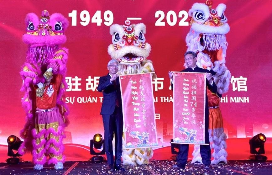 市人委会副主席武文欢（左）和中国驻本市总领事魏华祥接受贺语。